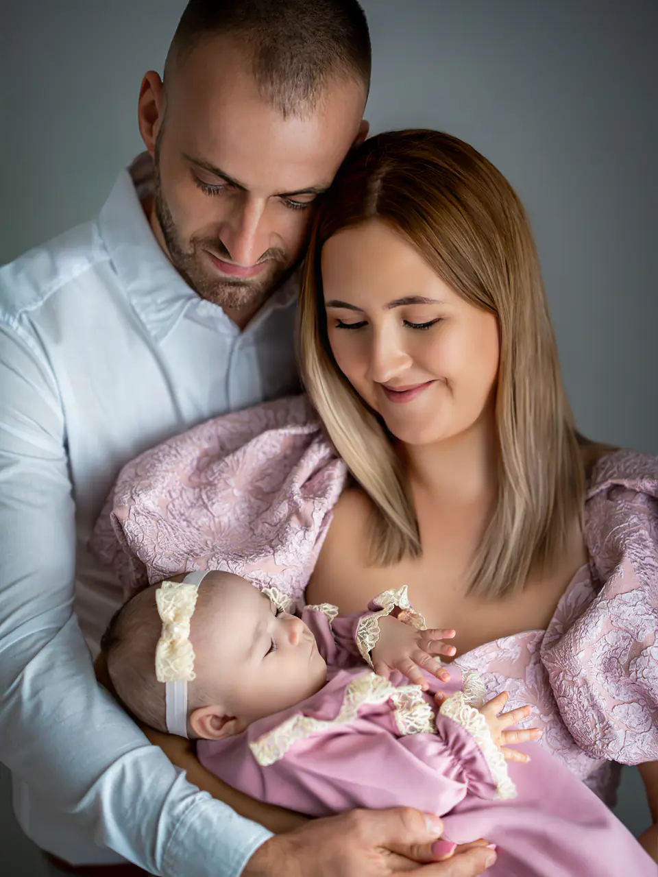 Eltern halten ihr schlafendes Baby im Studio