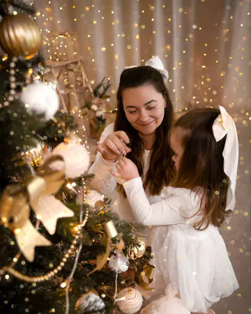 Mama und Tochter schmücken den Weihnachtsbaum