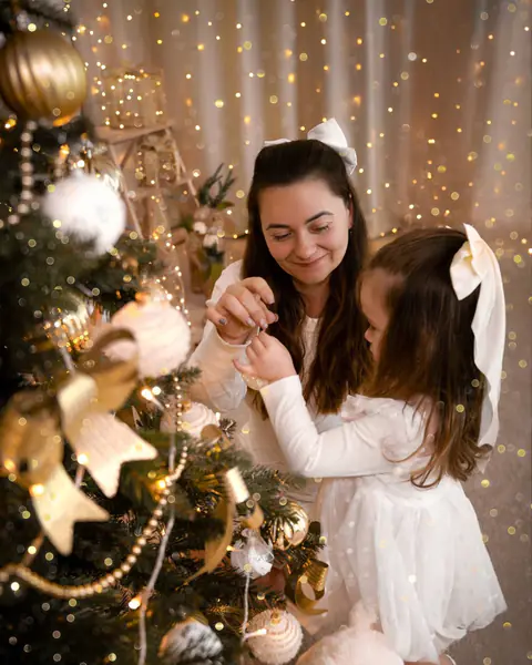 Mutter und Tochter schmücken gemeinsam den Weihnachtsbaum